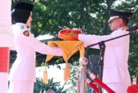 Naura Melia Putri saat menerima bendera merah putih dari Bupati Bone Andi Asman Sulaiman.