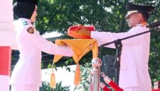 Naura Melia Putri saat menerima bendera merah putih dari Bupati Bone Andi Asman Sulaiman.