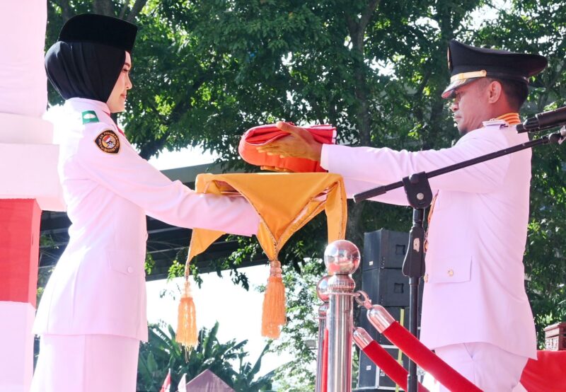 Naura Melia Putri saat menerima bendera merah putih dari Bupati Bone Andi Asman Sulaiman.